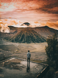 Rear view of man standing against mount bromo