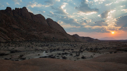 Scenic view of desert against sky during sunset