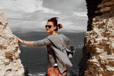 Man wearing sunglasses standing on rock