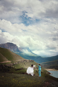 Beautiful wedding couple in the mountains. gorgeous bride and groom holding hands and dancing in the