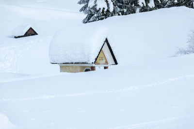 Snow covered houses on field by building