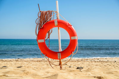 Lifeguard hut on beach against clear blue sky