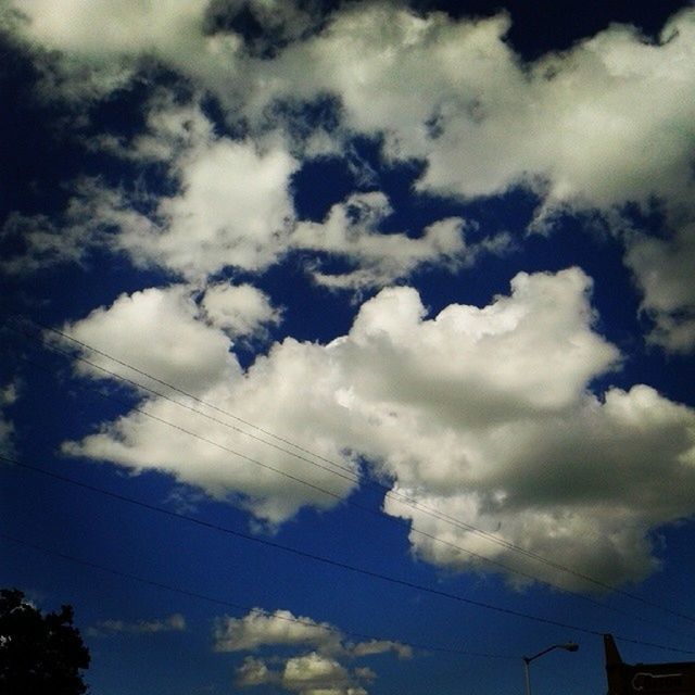 LOW ANGLE VIEW OF POWER LINES AGAINST CLOUDY SKY