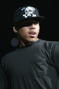 Portrait of young man wearing hat against black background