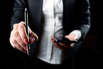 Midsection of businessman holding pen