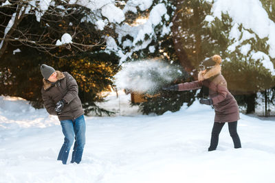 Full length of man standing on snow covered tree