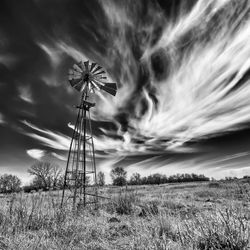 Low angle view of wind turbines on land