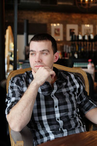 Portrait of young man standing in restaurant