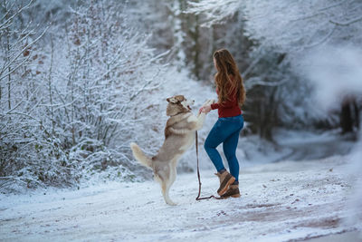 Full length of woman with dog during winter