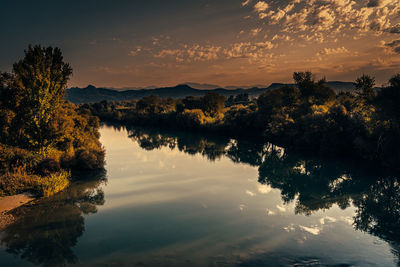 Scenic view of lake against sky at sunset