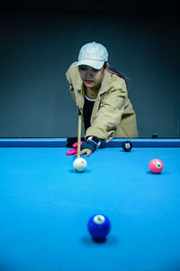 Midsection of woman playing pool