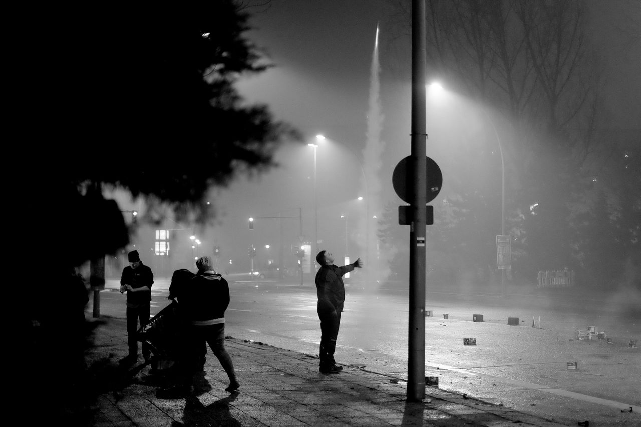 WOMAN STANDING BY RAILING AT NIGHT