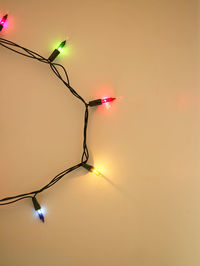 Close-up of illuminated string light over yellow background