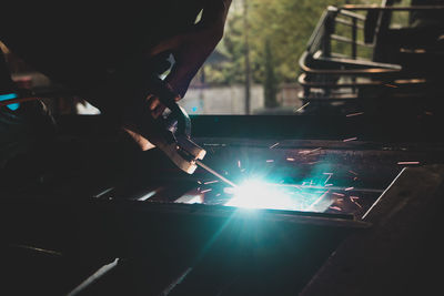 Cropped hand of man welding metal