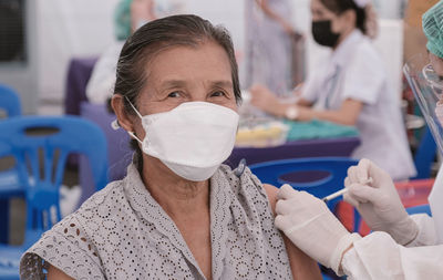 Portrait of senior woman wearing mask during vaccination