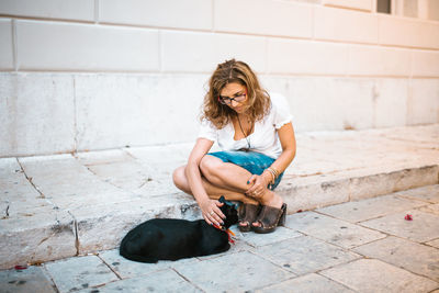 Full length portrait of woman sitting outdoors