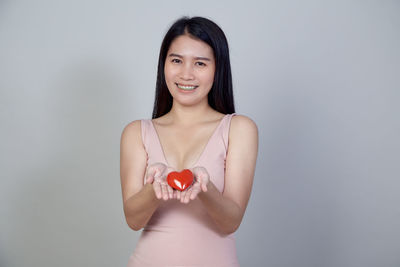 Portrait of a smiling young woman over white background