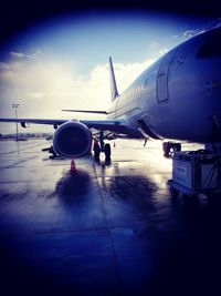 Airplane on airport runway against sky