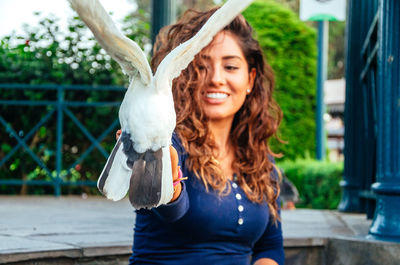 Beautiful young latina feeding a pigeon from the palm of her hand