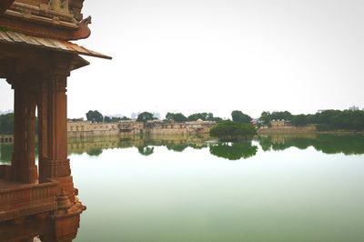 Reflection of built structure in water against clear sky