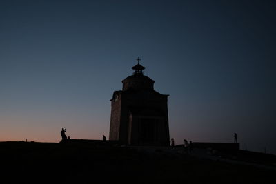 Silhouette lighthouse against clear sky