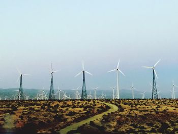 Windmill on field against clear sky