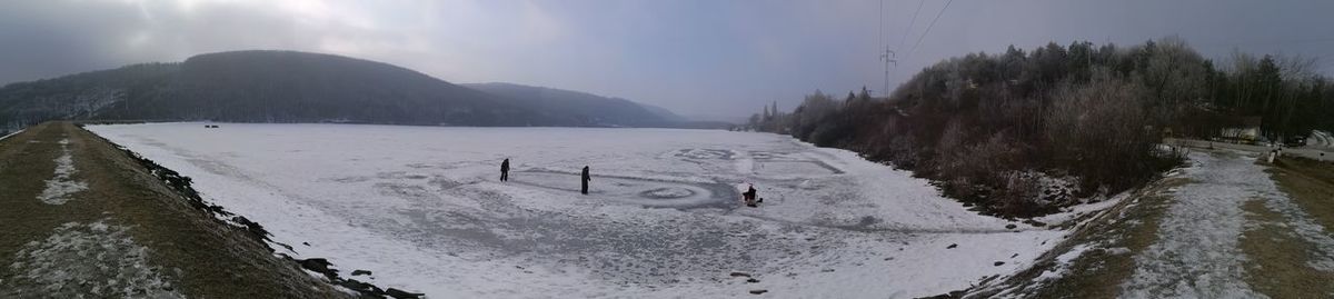 Panoramic view of snow covered mountains against sky