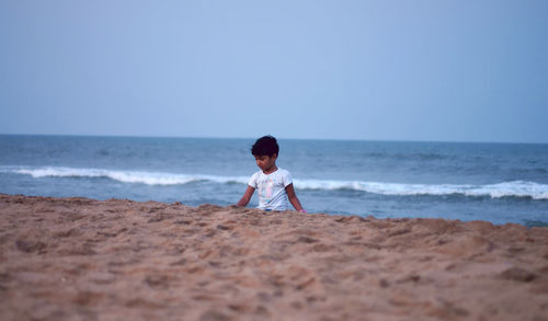 Full length of boy on beach against sky