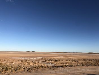 Scenic view of desert against clear blue sky