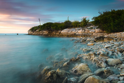 Scenic view of rocks in sea against sky