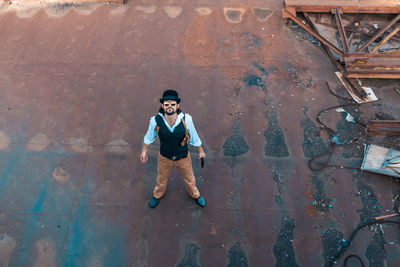 Full length portrait of young man standing against wall