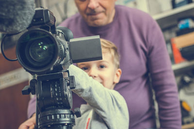 Boy with grandfather using television camera