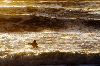 Scenic view of sea waves at sunset