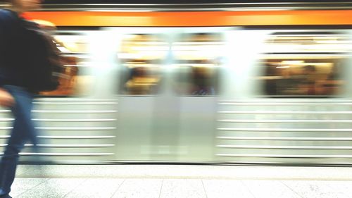 Blurred motion of woman on train at railroad station