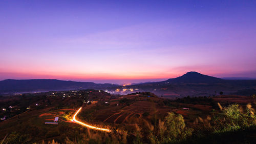 Aerial view of illuminated landscape against clear sky at sunset