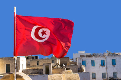 Low angle view of flag against buildings in city