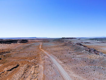 Scenic view of desert against clear blue sky