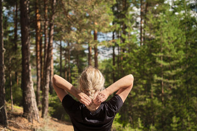 Rear view of woman standing in forest