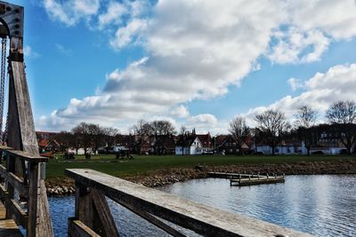 Scenic view of river by buildings against sky