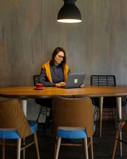 Woman using laptop while sitting on chair