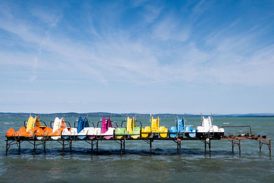 Scenic view of sea against sky with colourful water bikes
