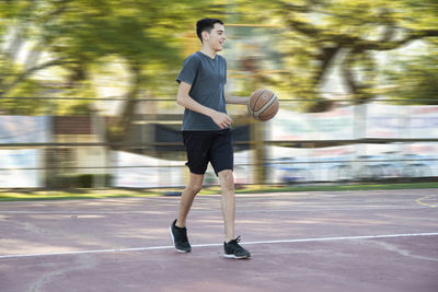 Portrait of teenage boy playing baskeball