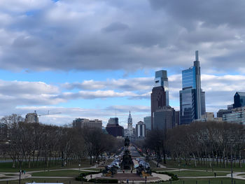 Buildings in city against cloudy sky