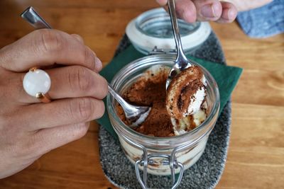 Midsection of person holding ice cream on table