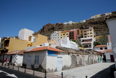 Buildings in city against clear blue sky