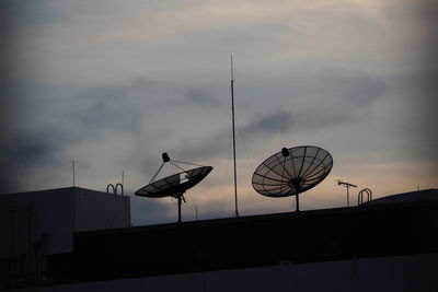 Low angle view of communications tower against sky during sunset