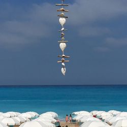 Close-up of decor hanging over beach against sky