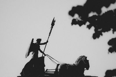 Low angle view of quadriga statue on brandenburg gate against clear sky