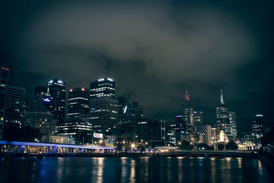 Illuminated buildings in city against sky at night