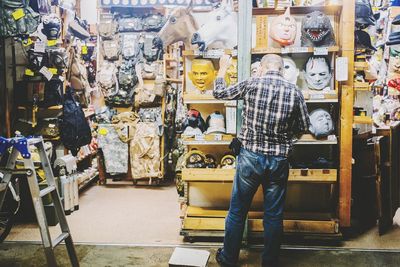 Rear view of man standing at mask store